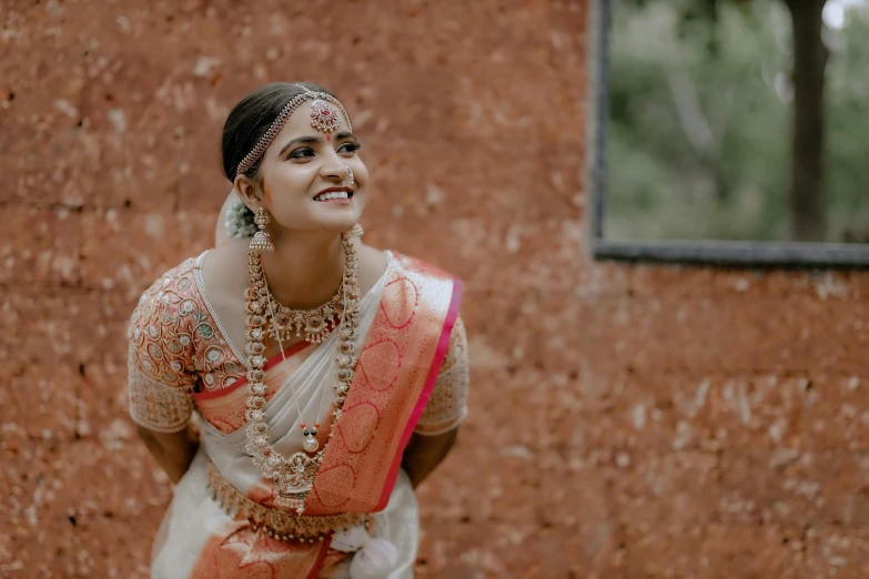 an indian bride smiling in front of a window