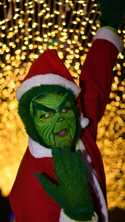 a costumed person wearing a green santa clause suit holding a green cigarette