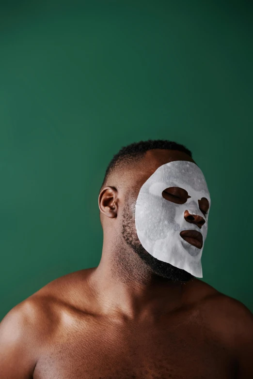 shirtless man with brown circles and white mask on