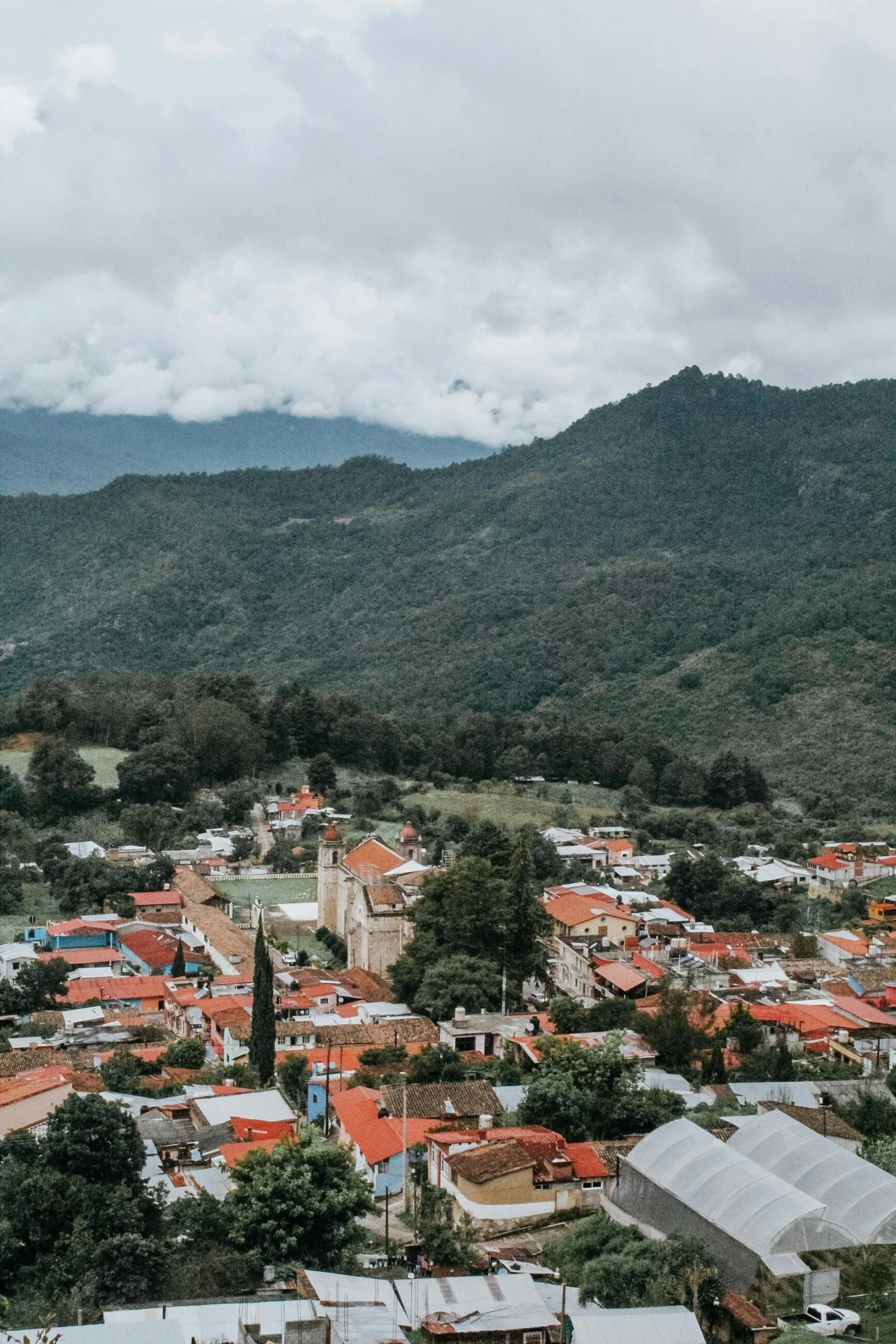 a town with an elevated area with mountains in the background