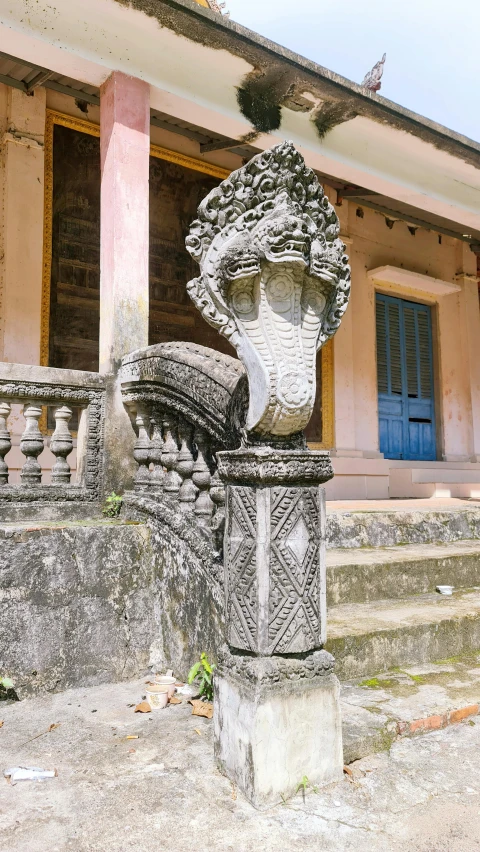 an ornate stone sculpture sits in front of a dilapidated building