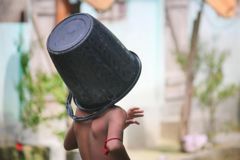 a person in a black head covering with a bag