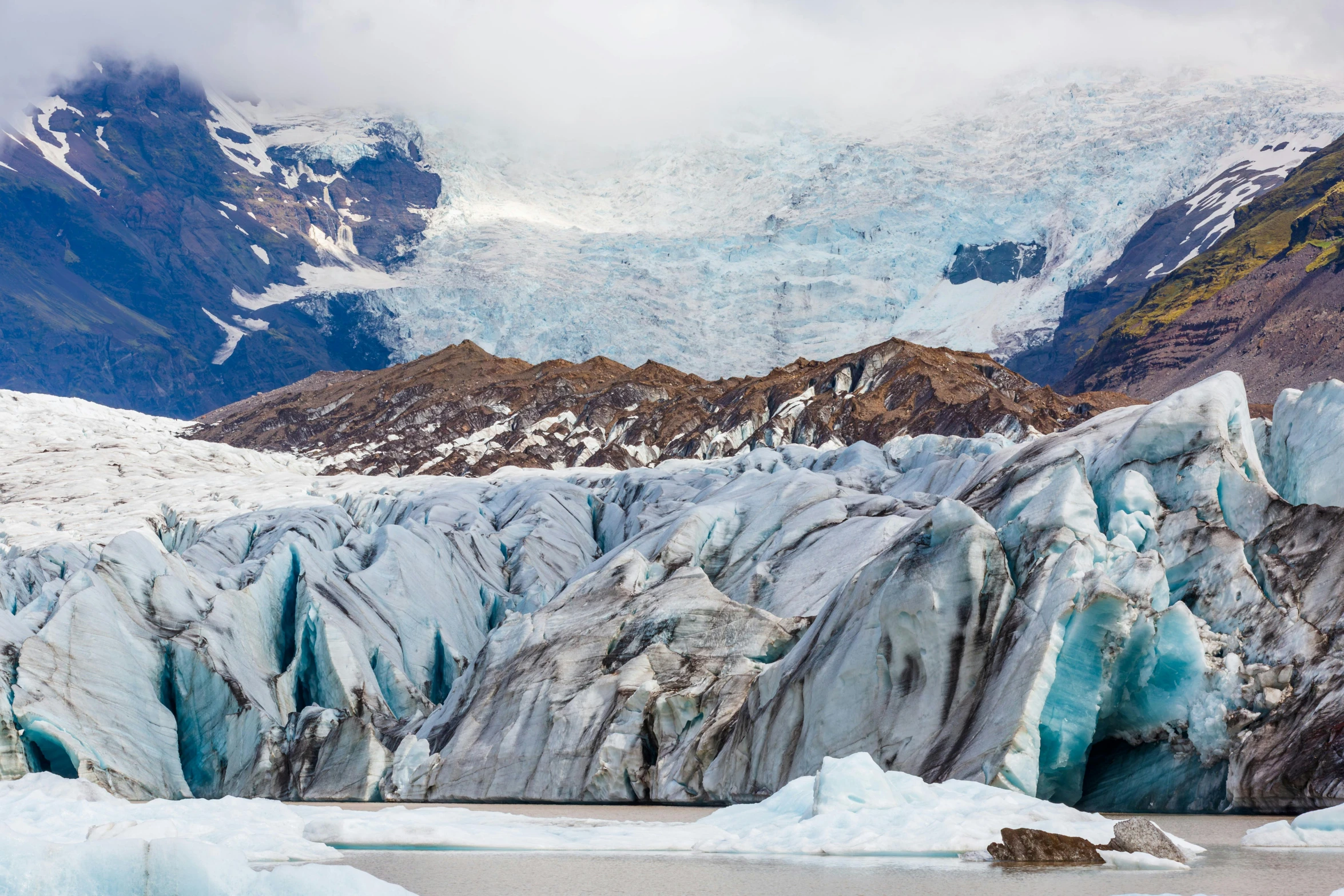 snow covered mountain landscape with ice formations in the foreground