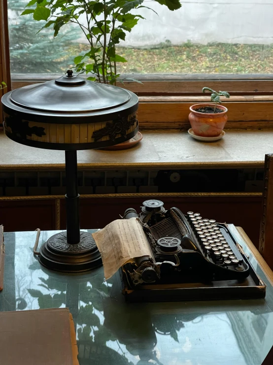 an old fashioned typewriter on a table next to a window