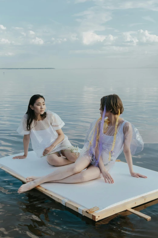 two girls in white outfits on a floating platform