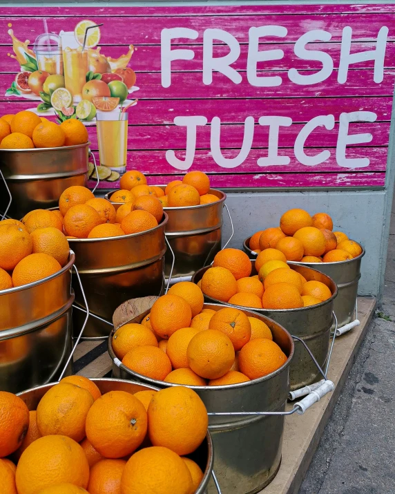 several buckets of oranges are sitting on a table