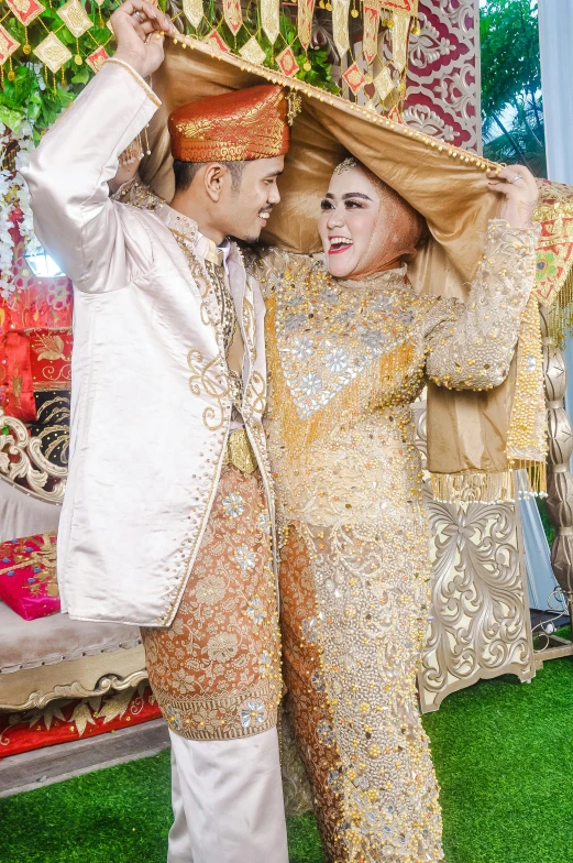 couple posing for pograph at outdoor ceremony with fancy cloth