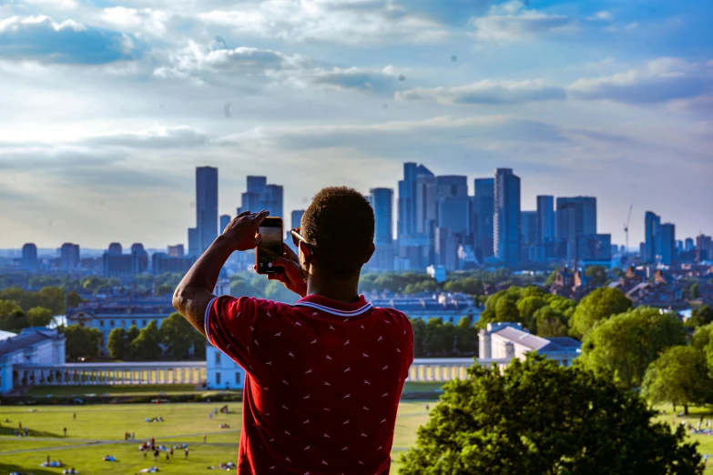 a man taking pictures on a city with his cell phone