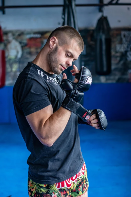 a young man in boxing gloves talking on the phone