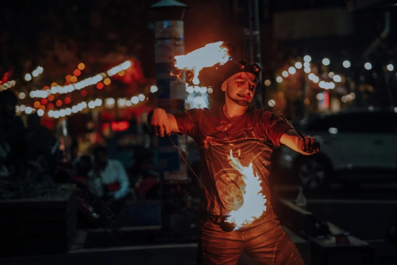 the man is holding fire torches around his body