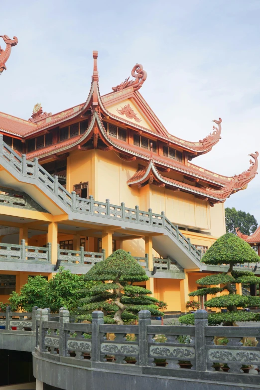 an oriental building has several trees and bushes around it