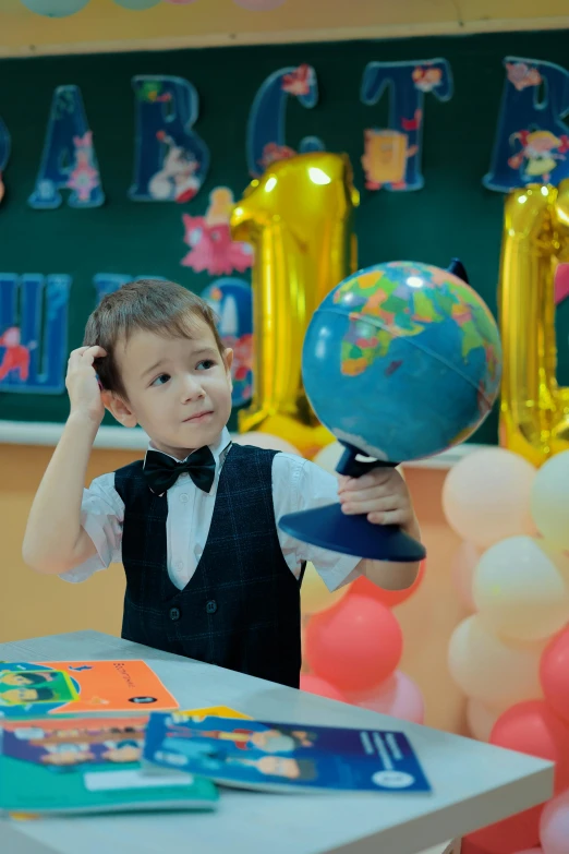 a little boy holding a balloon in his hair