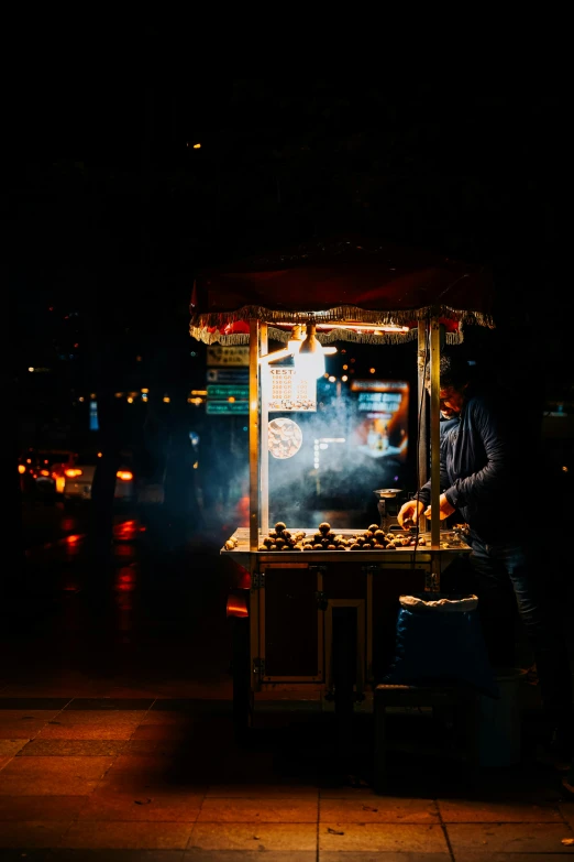 a vendor selling food on the street at night