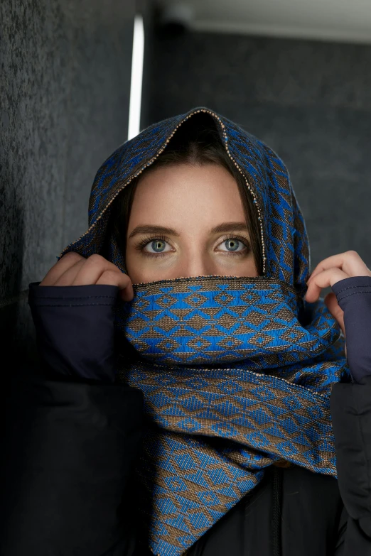 woman with black jacket and blue scarf around her neck