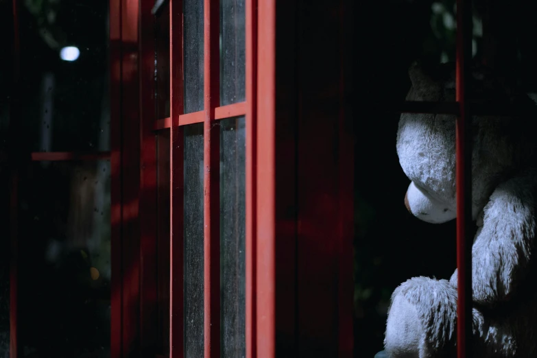 some white stuffed animals sitting in red windows