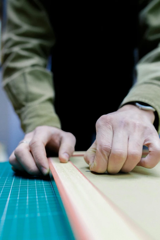 a person with a wooden block of tape  paper