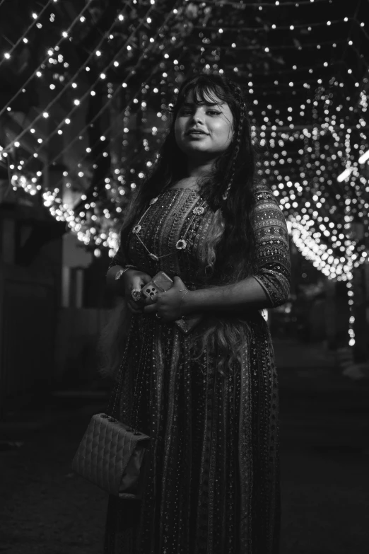 a woman in a dress and lights above her head is looking off into the distance