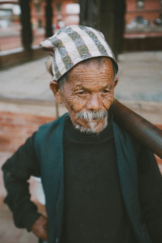 a man is carrying an old wooden stick in his hand