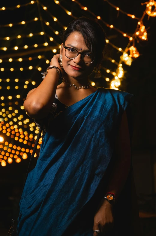 a lady in glasses with a lot of lights in the background