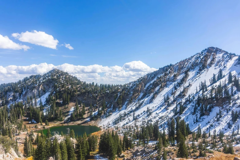 a mountain lake surrounded by trees and snow