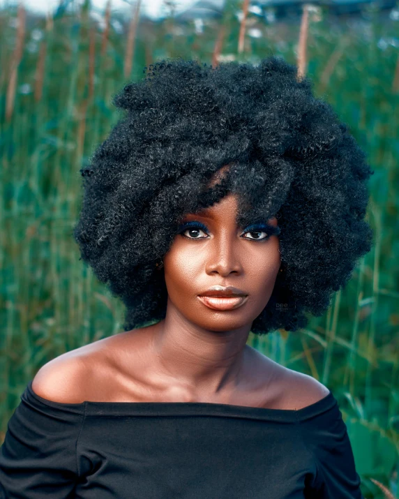 a woman with black afro with hair that is looking directly into the camera