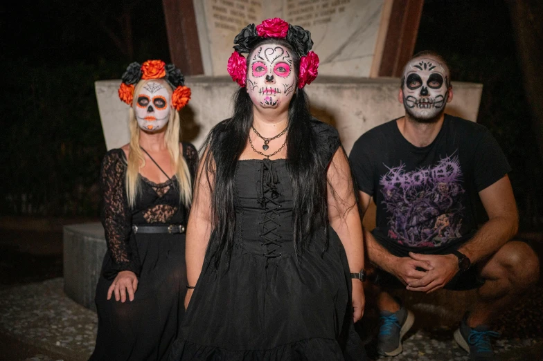 three people in costumes and one wearing face paint