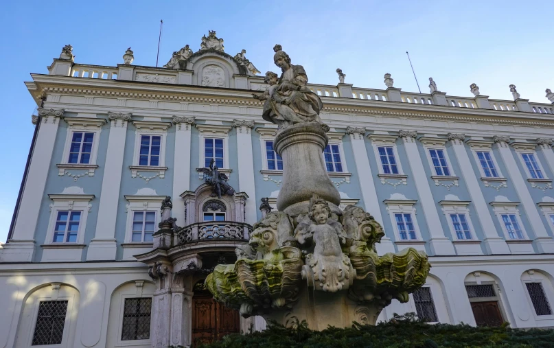 statue on top of a fountain in front of an old building