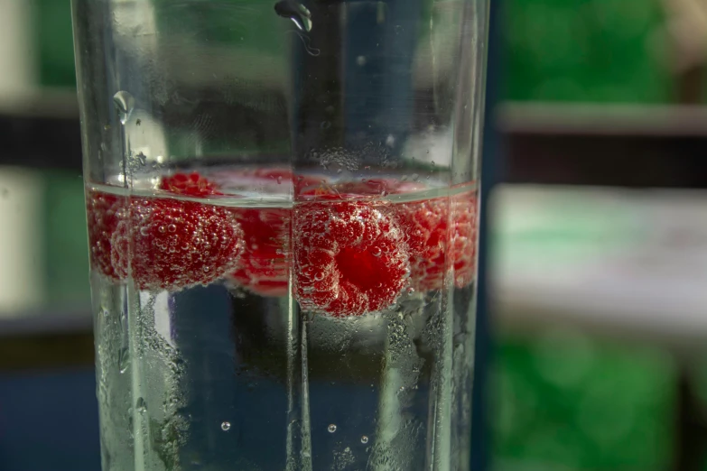 raspberries are frozen inside a glass in the sun