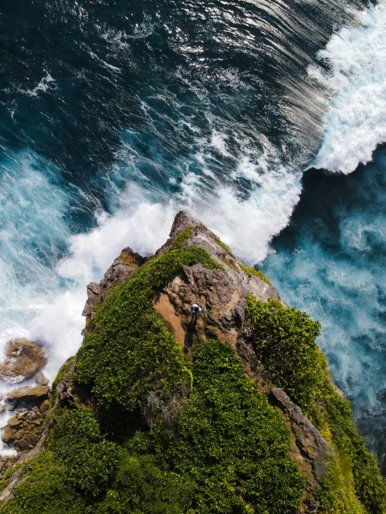 an island surrounded by crashing surf and ocean waves