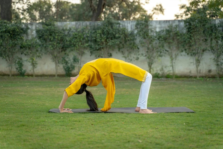 a person practicing a yoga pose in a field