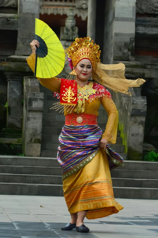 woman dressed in traditional chinese dance clothing walking down a paved street