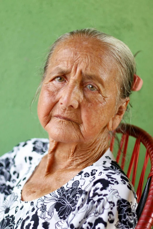 an old woman sitting in a chair with a smile on her face