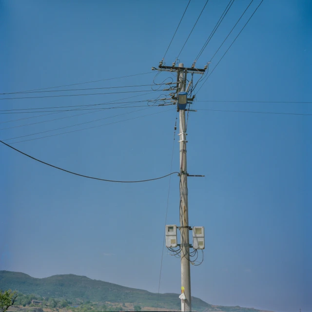 an electrical pole with a view of a mountain in the distance