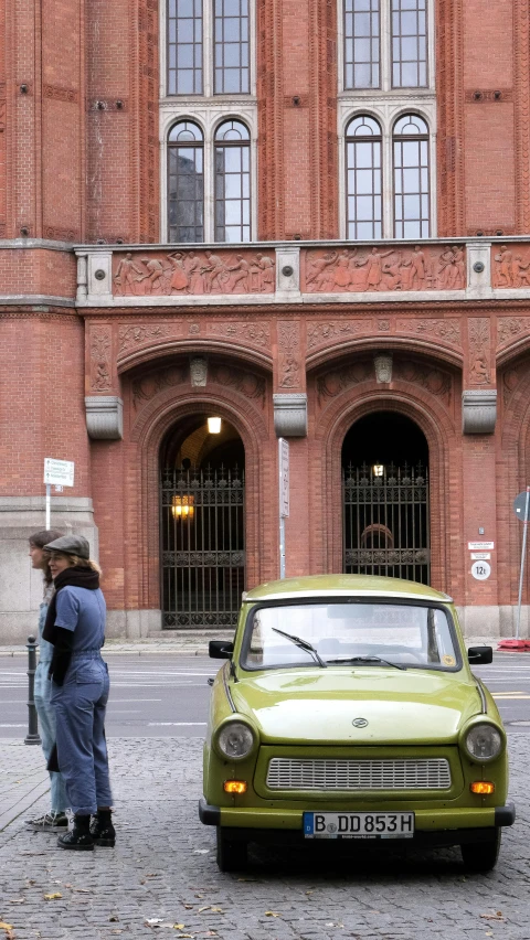 a man standing next to a car in front of a building