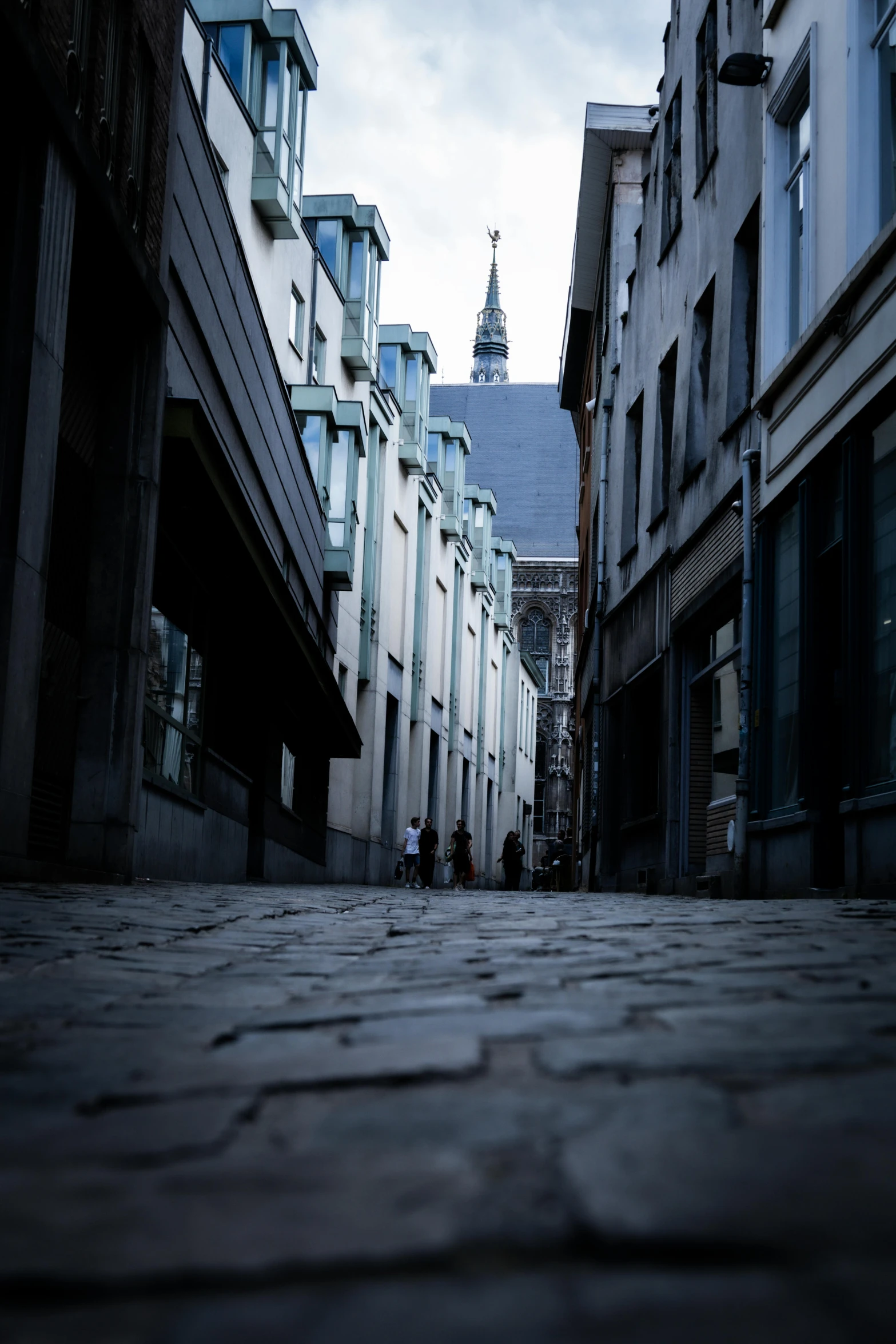 people are walking down an alley in the city