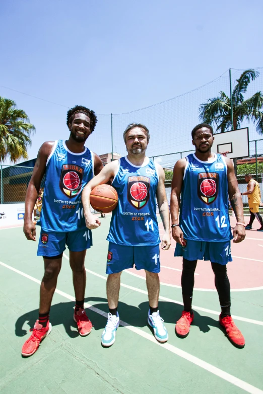 three young men holding basketballs in a basketball court