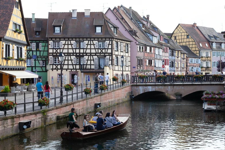 a group of people ride on a small boat down a waterway