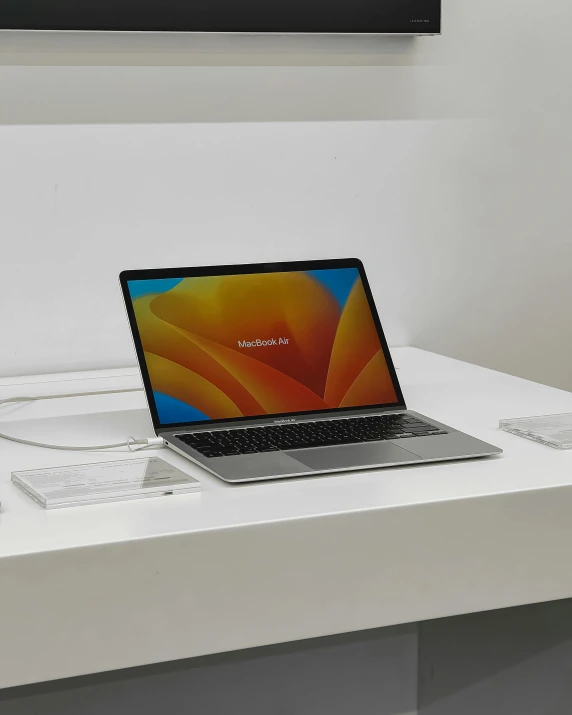 a laptop computer sitting on top of a white desk