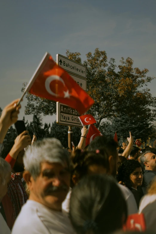 several people waving turkish and turkish flags
