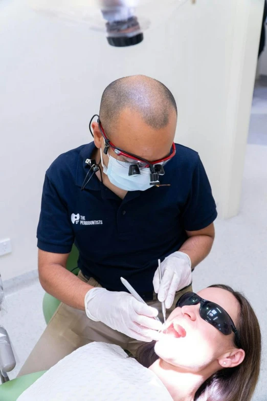 man and woman having facial checkup with a woman with a mouth ce