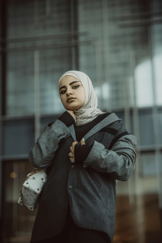 the woman is wearing a scarf and holding her jacket