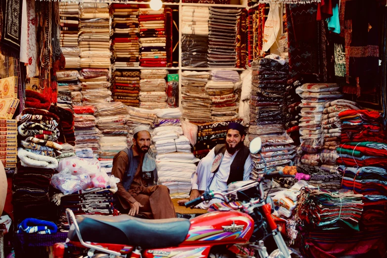 two men are sitting in front of some clothing