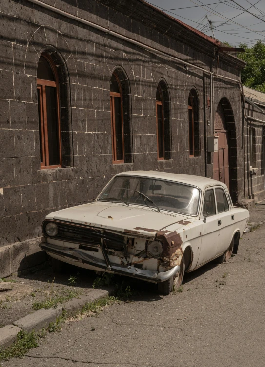 an old, rusty white car is parked in a deserted street