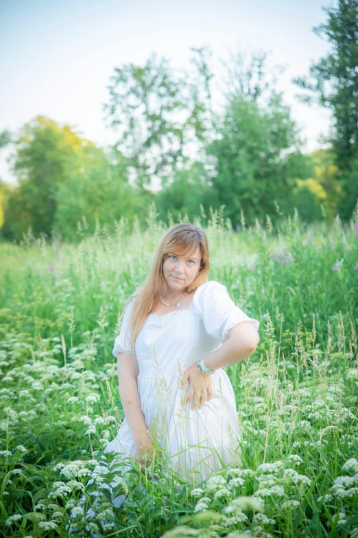 a woman standing in the middle of the grass