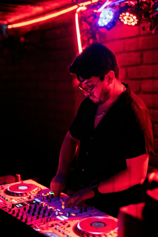 a dj plays at a nightclub while the light is on