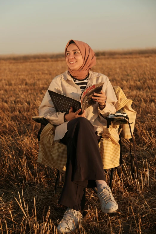 a woman in a headscarf sitting on a field