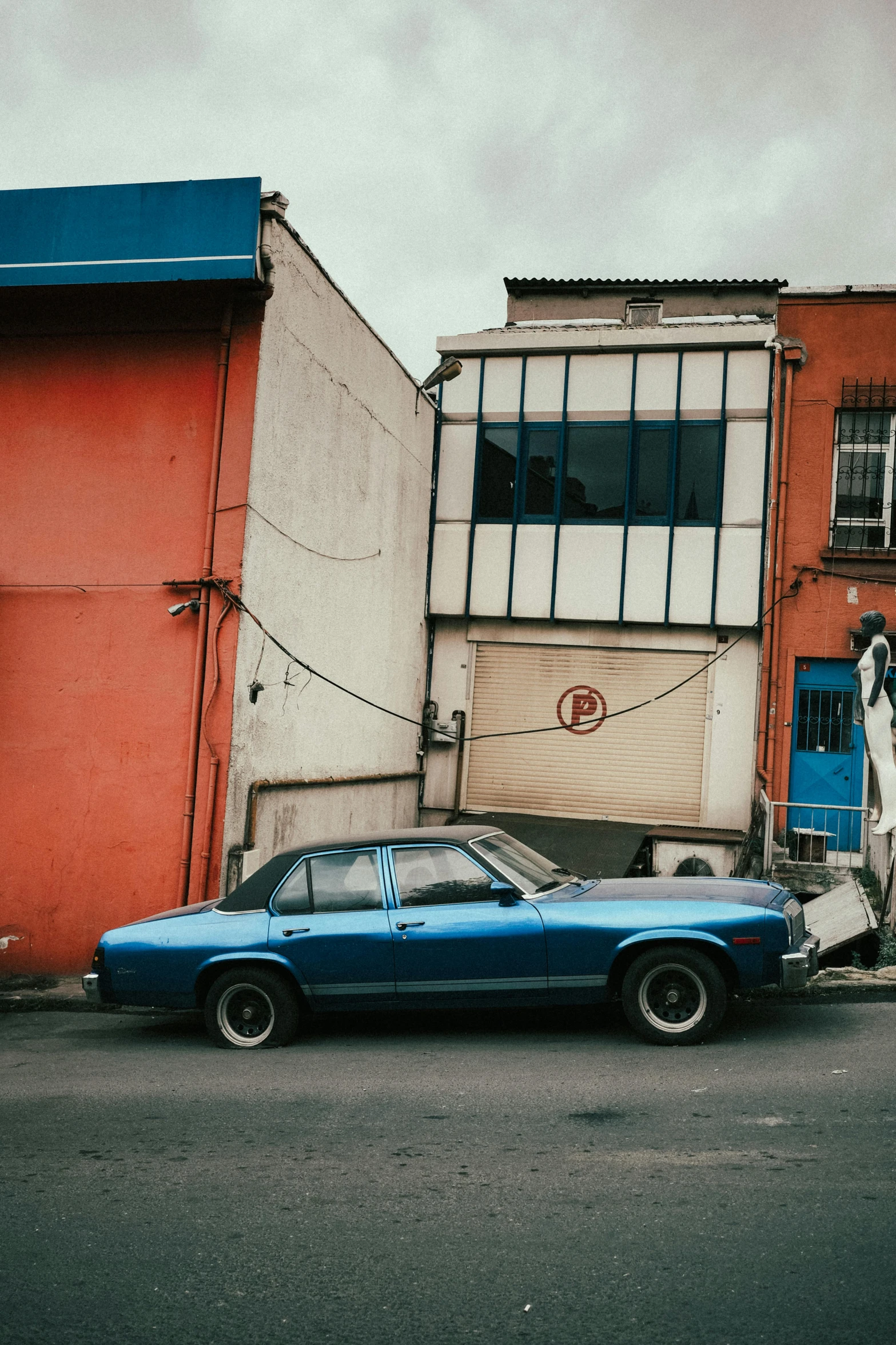 an old car parked on the side of the street near colorful buildings