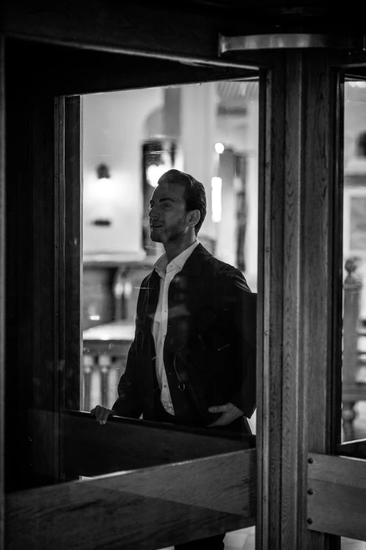 a man that is looking into the window of a building