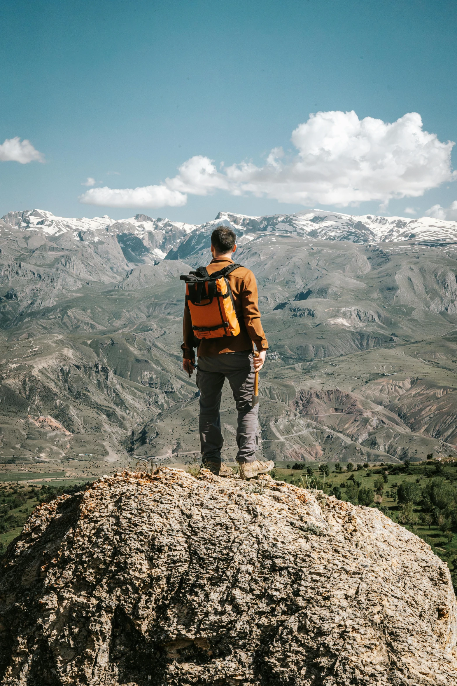 a man with a backpack is standing on top of a mountain