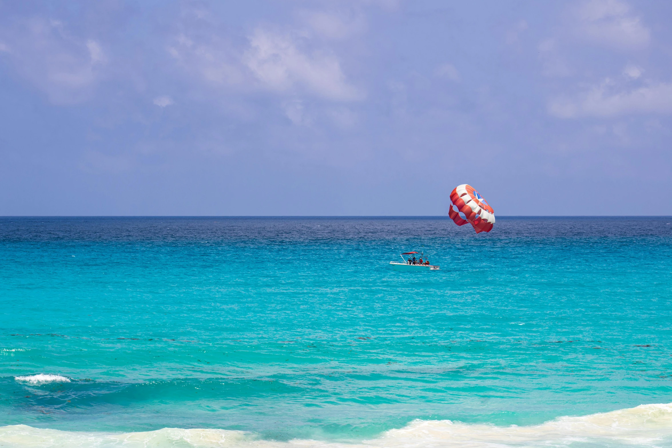 a man riding a board on top of a blue ocean